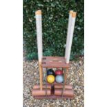 A FOUR PIECE CROQUET SET Complete with four mallets and balls, contained on a fitted rack with a