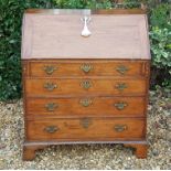 A CIRCA 1800 OAK WRITING BUREAU The fall front enclosing an arrangement of six drawers and a