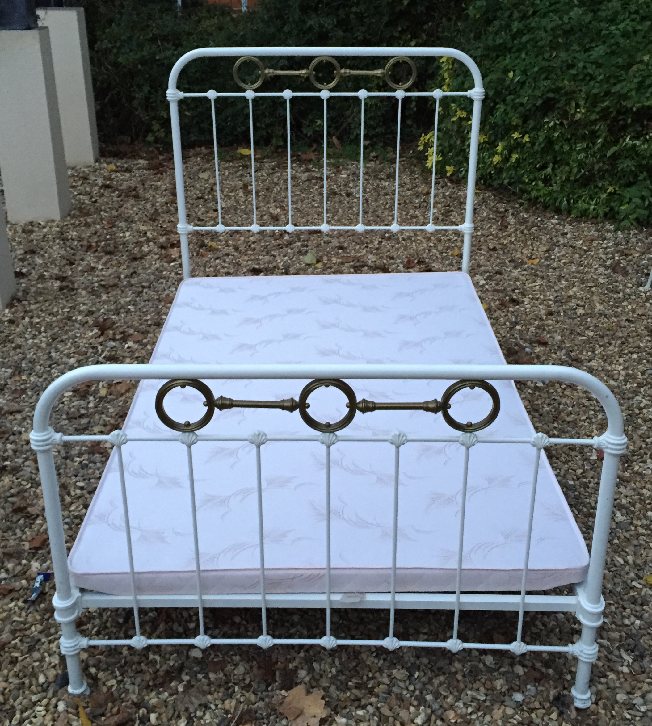 A VICTORIAN WHITE PAINTED IRON AND BRASS BED With cast iron shell and brass ring decoration. (h