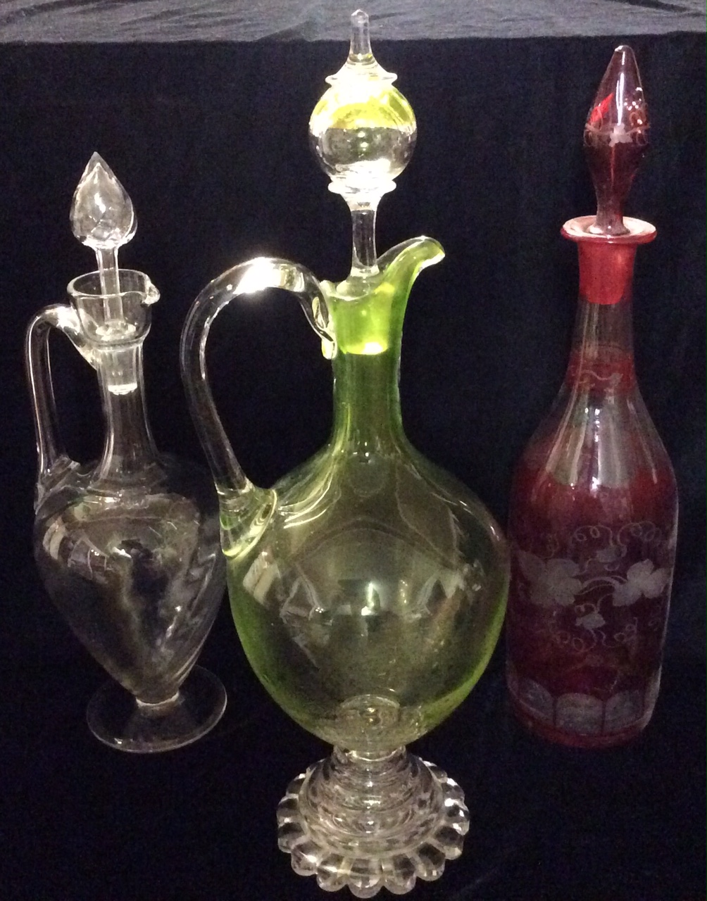 A VICTORIAN GREEN GLASS BULBOUS CLARET JUG With a clear glass handle and foot rim, together with a