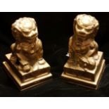 A PAIR OF 20TH CENTURY CAST BRASS TEMPLE DOGS OF FO One having a ball under foot, the other a
