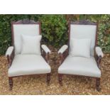 A PAIR OF EDWARDIAN WALNUT OPEN ARMCHAIRS Having carved backs and teal upholstery with lozenge and