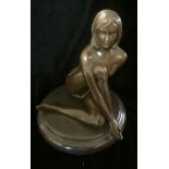 A BRONZE SCULPTURE OF A FEMALE NUDE Seated, with shoulder length hair, raised on a black marble