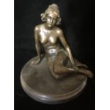 A BRONZE SCULPTURE OF A FEMALE NUDE Seated with hair tied back, raised on a black marble base. (h