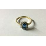 A HALLMARKED 9CT GOLD, BLUE TOPAZ AND DIAMOND RECTANGULAR CLUSTER RING Step cut topaz claw set to