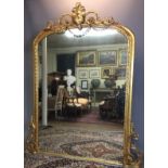 A LARGE 19TH CENTURY GILT FRAMED OVERMANTEL MIRROR Crested with a shield form cartouche and swags