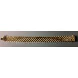 A VINTAGE 9CT GOLD BRACELET Having an usual designed link comprising of four wave effect lines,