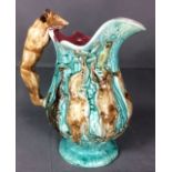 A 19TH CENTURY CONTINENTAL MAJOLICA POTTERY JUG moulded with a rampant fox handle, various game