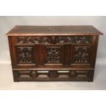 AN 18TH CENTURY OAK MULE CHEST The hinged top over carved panels with foliate motif.