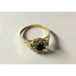 A HALLMARKED 9CT GOLD, SAPPHIRE AND WHITE GEMSTONE FLOWERHEAD CLUSTER DRESS RING The oval cut
