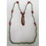 A TWO COLOUR JADE BEAD NECKLACE AND PENDANT The pendant carved as a mantis on a leaf, suspended from