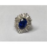 A VINTAGE 18CT WHITE GOLD, SAPPHIRE AND DIAMOND CLUSTER DRESS RING The oval cut sapphire claw set to