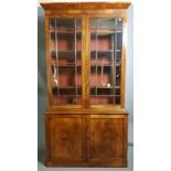 A 19TH CENTURY MAHOGANY BOOKCASE With cushion cornice above two glazed doors and flame mahogany