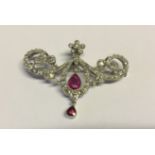 AN EDWARDIAN BELLE ÉPOQUE STYLE PLATINUM, PINK SAPPHIRE AND DIAMOND BROOCH/PENDANT Of open scrolling