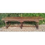 AN ANTIQUE SOLID YEW REFECTORY TABLE The four plank top above a carved frieze, raised on six