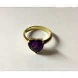 AN 18CT GOLD AND AMETHYST DRESS RING The heart shaped amethyst claw set to a plain tapering shank,