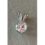 A 9CT WHITE GOLD AND DIAMOND PENDANT Having a single round cut diamond and butterfly wing style