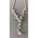 A 9CT WHITE GOLD AND DIAMOND NECKLACE Floral design with diamond encrusted branches.