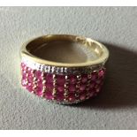 A 9CT GOLD, RUBY AND DIAMOND HALF ETERNITY RING Three rows of round cut rubies with two rows of