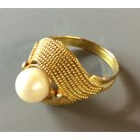 A VINTAGE 9CT GOLD AND PEARL SET RING Having a single pearl held in an unusual rope twist design (