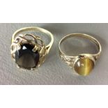 A 9CT GOLD AND CABOUCHON CUT TIGERS EYE DRESS RING Held in an engraved gold shank, together with a