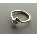 A 9CT GOLD AND DIAMOND HALF TWIST RING Nine pave set diamonds forming a lozenge shape and held in