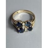 A VINTAGE 14CT GOLD, DIAMOND AND SAPPHIRE RING Asymmetrically set with four diamonds flanked by