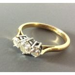 AN 18CT GOLD, THREE STONE DIAMOND RING having a round cut diamond, flanked by two smaller diamonds