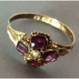 A VICTORIAN 9CT GOLD, GARNET AND SEED PEARL RING Having a single seed pearl surrounded by four