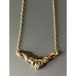 A 9CT GOLD AND DIAMOND NECKLACE The pierced 'V' design set with diamonds and suspended from a 9ct