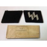 A PAIR OF WORLD WAR II GERMAN SS COLLAR PATCHES ON BLACK FABRIC Complete with original envelope
