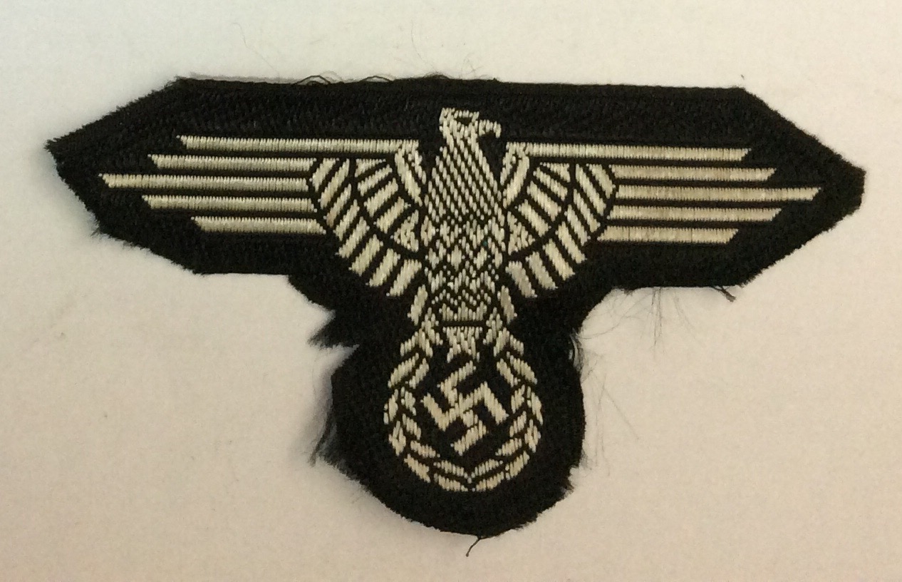 A WORLD WAR II GERMAN SS ARM BADGE Having the German eagle on a black rayon fabric ground.