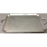 A LARGE EARLY 20TH CENTURY ART DECO STYLE SILVER PRESENTATION TRAY Applied with twin handles and