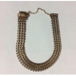 A VINTAGE 9CT GOLD FANCY LINK BRACELET Having three rows of horseshoe links forming a mesh bracelet.