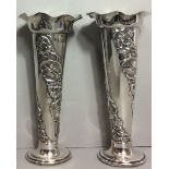 A PAIR OF EDWARDIAN SILVER TRUMPET VASES Having flared rims and embossed with lily pads and flowers,