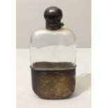 A LATE VICTORIAN LEAD GLASS HIP FLASK Having silver hinged cap over a faceted glass upper section