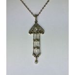 AN ART NOUVEAU BIMETAL AND DIAMOND PENDANT With filigree decoration and suspended pearl drop, sold