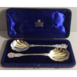 MAPPIN & WEBB, A PAIR OF SILVER GILT BERRY SPOONS The finial embossed with grapes and vine leaves