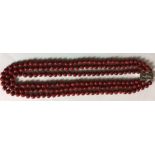 A VINTAGE RED HARDSTONE AND SILVER CHOKER NECKLACE Three strands of beads leading to a rectangular