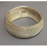 TIFFANY & CO., A LADIES' SILVER LINK BANGLE Made up of articulated silver 'S' links with Tiffany &