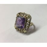 A 14CT GOLD AND AMETHYST RING The single amethyst flanked by pierced filigree decoration (size I).