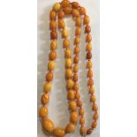 AN ANTIQUE NATURAL BALTIC AMBER NECKLACE The single string of graduating oval beads interspersed