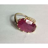 AN 18CT GOLD, RUBY AND DIAMOND RING The faceted oval cut ruby flanked by two rows of graduating