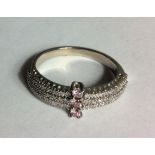 A 14CT WHITE GOLD, FANCY DIAMOND AND DIAMOND RING The three round cut pink diamonds set in a