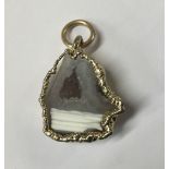 A YELLOW METAL AND ROCK CRYSTAL PENDANT With flat cut rock crystal in a naturalistic mount.