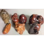 A COLLECTION OF SEVEN 20TH CENTURY ORIENTAL CARVED WOODEN NETSUKE Including a Buddha head, monkey