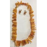 A VINTAGE NATURAL BALTIC AMBER NECKLACE The single strand of conical shards on an oval amber screw