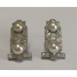 A PAIR OF ART DECO PLATINUM, DIAMOND AND PEARL EARRINGS Having two pearls centred by a round cut