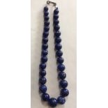 A VINTAGE LAPIS LAZULI NECKLACE The single strand of graduating spherical beads set on a white metal