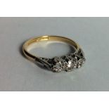 A VINTAGE 18CT GOLD AND DIAMOND THREE STONE RING Three graduating round cut diamonds, illusion set